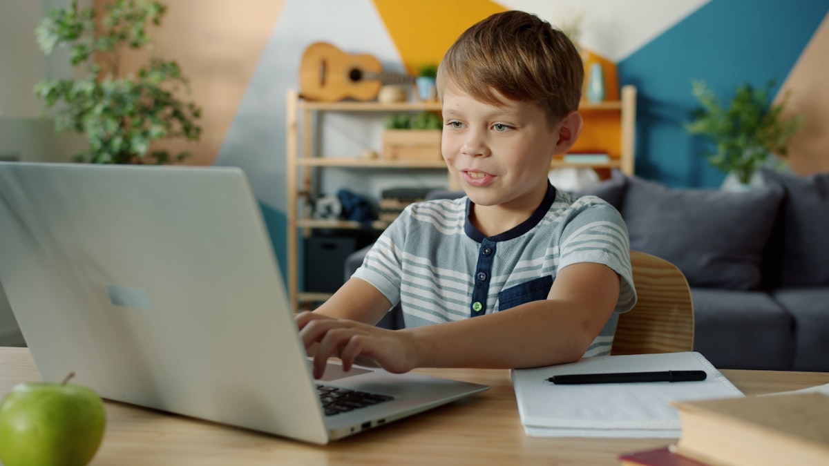 A child learning Arabic online with Harf, worksheet visible on the desk